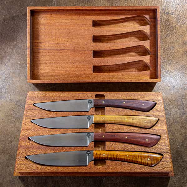 four carbon steel steak knives in a wooden box